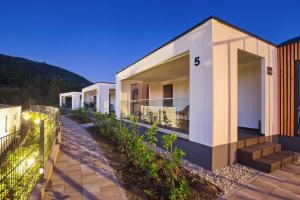 eine Reihe von Häusern mit einem Zaun davor in der Unterkunft Mobile Homes Camping Plitvice in Smoljanac