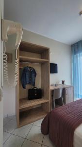 una camera con letto, scrivania e tavolo di Hotel Adigrat a Riccione