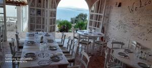 a dining room with tables and chairs and the ocean at Stefanosplace ApartHotel Sea View in Barbati