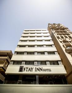 um edifício alto com uma placa que diz para ficar no hotel em Stay Inn Cairo Hotel no Cairo