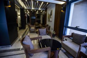 Stay Inn Cairo Hotel في القاهرة: غرفة انتظار مع كراسي وطاولة ونافذة