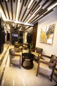 Stay Inn Cairo Hotel في القاهرة: لوبي فيه كراسي وطاولة في الغرفة