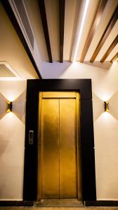 a gold elevator door in a building with lights at Stay Inn Cairo Hotel in Cairo
