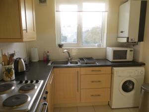 a kitchen with a sink and a washing machine at Sandy Shores in Hunstanton