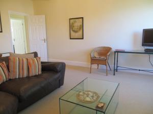 a living room with a leather couch and a glass table at Sandy Shores in Hunstanton