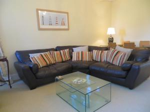 a living room with a leather couch and a coffee table at Sandy Shores in Hunstanton