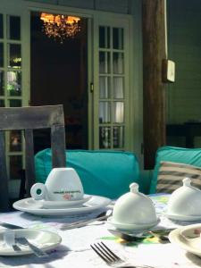 una mesa con platos blancos encima en Pousada das Gêmeas en Ilha do Mel