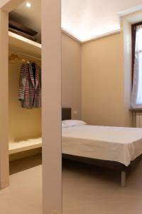 um pequeno quarto com uma cama e uma janela em ROMA COMFORT em Casale Monferrato