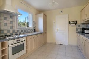 a large kitchen with a sink and a window at Maison moderne pour 6 personnes à Sarzeau in Sarzeau +11 photos