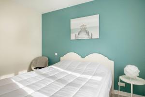 um quarto com uma cama branca e uma parede azul em Maison moderne pour 6 personnes a Sarzeau em Sarzeau