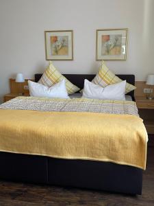 a bedroom with a large bed with a yellow blanket at Gästehaus Ute Müller in Wimbach