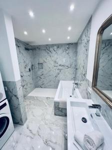 Baño blanco con bañera y lavamanos en Exclusive Poolvilla Patricia - Camp de Mar, en Andratx