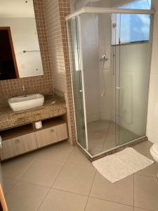 a bathroom with a glass shower and a sink at COMFORT DUPLEX in Rio das Ostras +15 photos
