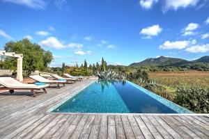 - une piscine avec des chaises longues sur une terrasse en bois dans l'établissement Villa Son Bennasar by Slow Villas, à Felanitx