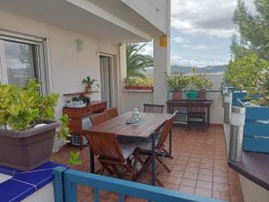 patio z drewnianym stołem i krzesłami na balkonie w obiekcie PLAYA ALMARDA CORINTO, PISCINA, WIFI,2 TERRAZAS, BARBACOA,TRANQUILo w mieście Sagunto