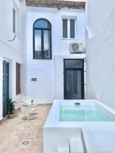 une maison blanche avec une baignoire dans une cour dans l'établissement Casa del Azucar, à Motril