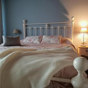 - une chambre avec un lit blanc et une tête de lit blanche dans l'établissement Agriturismo La Casetta - ospitalità rurale familiare, à Montese