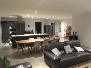 a living room with a couch and a table and a kitchen at À mont nos hôtes 2 in Mollans-sur-Ouvèze