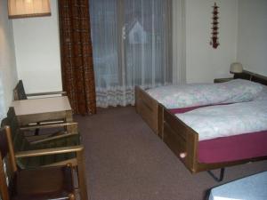 1 dormitorio con 1 cama, 1 silla y 1 ventana en Hotel Walida en Bönigen
