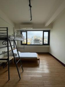 ein Schlafzimmer mit einem Etagenbett und einem Fenster in der Unterkunft Chiayi Petite Hostel in Chiayi