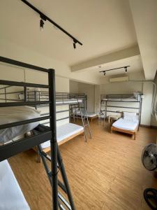 een kamer met meerdere stapelbedden in een gebouw bij Chiayi Petite Hostel in Chiayi City