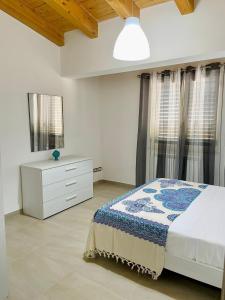 Schlafzimmer mit einem Bett, einer Kommode und Fenstern in der Unterkunft Il Bocciolo - Locazione turistica in Scilla