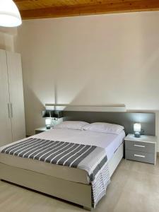um quarto com uma cama grande e duas mesas de cabeceira em Il Bocciolo - Locazione turistica em Scilla