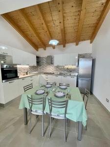 a kitchen with a table with chairs and a refrigerator at Il Bocciolo - Locazione turistica in Scilla