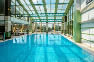 a large swimming pool inside of a building at Welna Eco Spa Resort in Tarusa