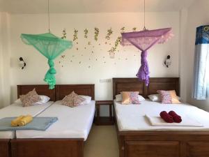 dwa łóżka w pokoju z parasolami na ścianie w obiekcie Anna Tourist Inn w Negombo
