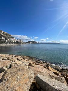 uma vista para uma praia com rochas e o oceano em Sweet Home Alicante em Alicante