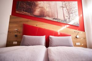 a bedroom with a red headboard and two white pillows at La Filanda Relax&Gourmet in Denno