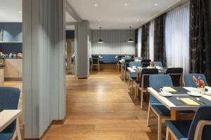 a dining room with tables and blue chairs at Hotel Continental in Zermatt