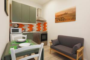 a kitchen with a table and a couch in a kitchen at SweetLittleHouse47 - Dentro le mura, parcheggio gratuito in Siena +15 photos