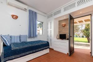 a bedroom with a bed and a television in it at Akisol Santa Luzia Teltale in Santa Luzia