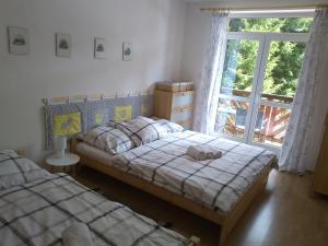 a bedroom with two beds and a window at Apartmány Mirka a Maťko in Donovaly