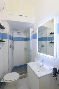 a bathroom with a sink and a toilet and a mirror at SweetLittleHouse47 - Dentro le mura, parcheggio gratuito in Siena