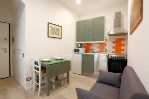 a small kitchen with a table and a couch in a room at SweetLittleHouse47 - Dentro le mura, parcheggio gratuito in Siena