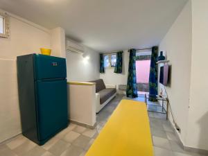 salon z niebieską lodówką i żółtym dywanem w obiekcie Casa Maremma w mieście Castiglione della Pescaia