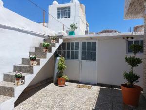 a white house with stairs and potted plants at Depa #6 Tipo Loft en Planta Alta en Centro Histórico in Zacatecas