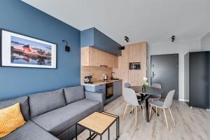 a living room with a couch and a table at Blue Mandarin - Chlebova Apartments in Gdańsk