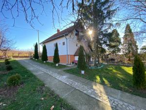 a small white house with a tree and a sidewalk at Heritage kuća za odmor in Arandelovac