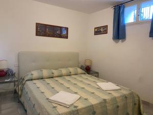a bedroom with a bed with two towels on it at Casa Maremma in Castiglione della Pescaia