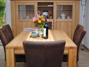 a wooden table with a bottle of wine and flowers on it at Ferienhaus Rathje an der Schlei in Fahrdorf in Fahrdorf +8 photos