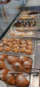 una vitrina llena de diferentes tipos de donuts en Hotel Elisabetta 2 stelle en Cattolica