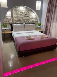 a bedroom with a large bed with pink lighting at In The Castle II- House in Ioannina