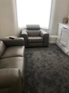 a living room with a couch and a chair and a window at Modern 2 bed sleep 5 close to Anfield Stadium in Liverpool