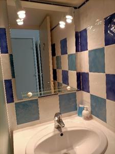 uma casa de banho com um lavatório e um espelho em Maison avec piscine collective sur Gruissan 6MIN39 em Gruissan