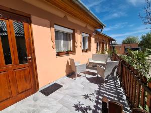 a patio with chairs and a wooden door at Kriszta apartman in Balatongyörök