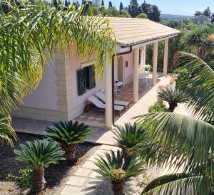 a house with a patio and palm trees at villa Bismarkia in Siracusa